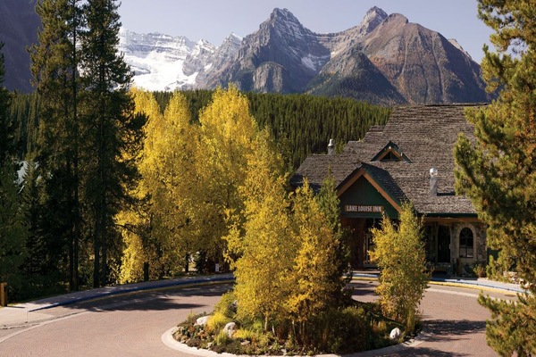 Arrive at the charming entrance framed by vibrant autumn colors and majestic mountains.