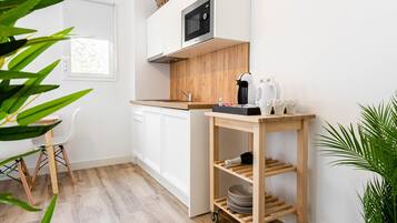 Eine moderne Küche mit weißen Schränken, einer Mikrowelle und einer Holz Arbeitsplatte.