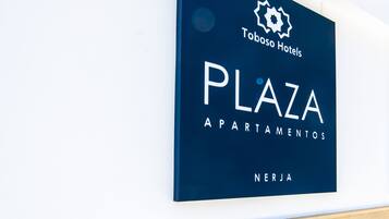 Una señalización indica 'Toboso Hotels Plaza Apartamentos' con un logotipo y el nombre 'NERJA'.