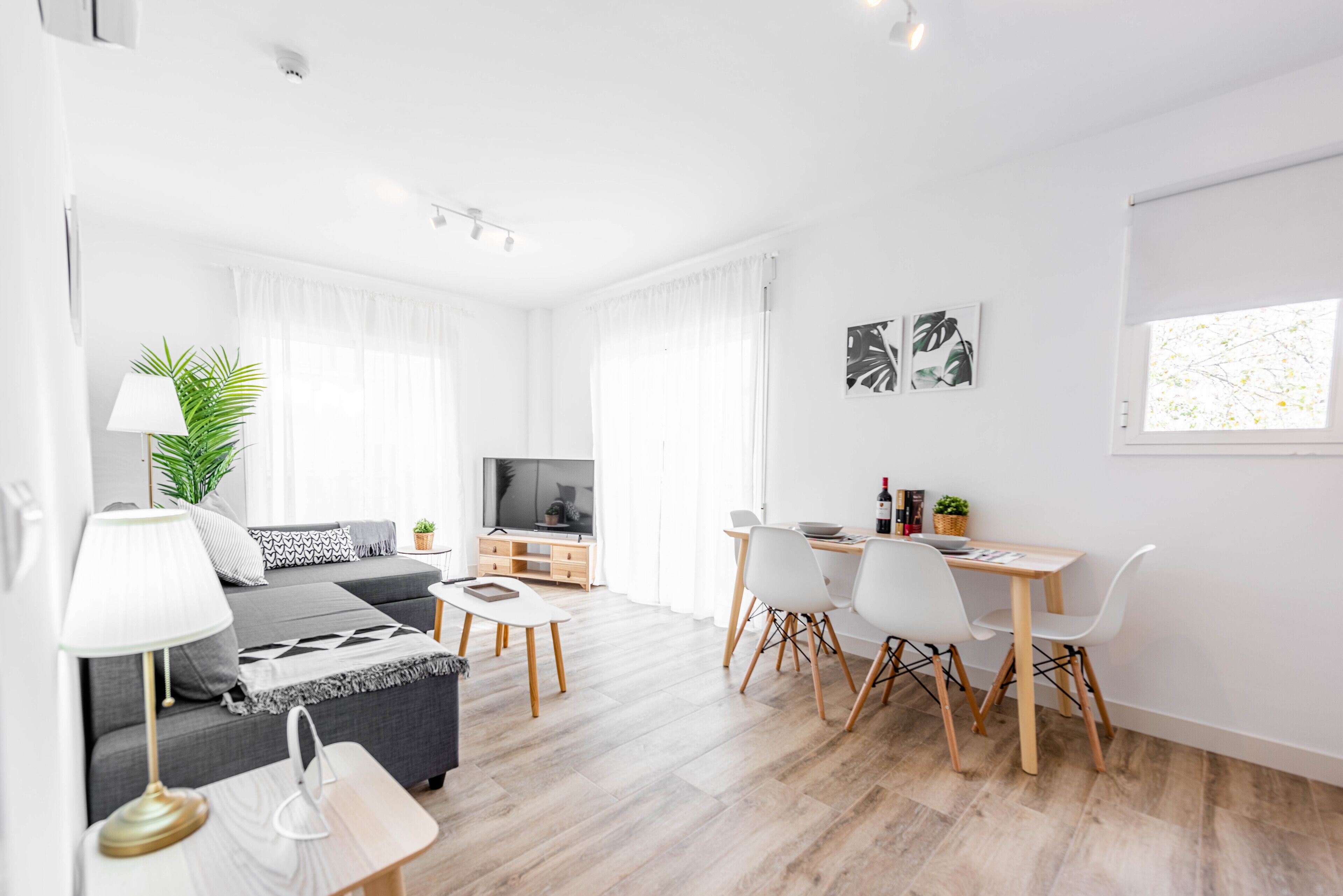 Un salon moderne avec un canapé, une table basse et un coin repas.