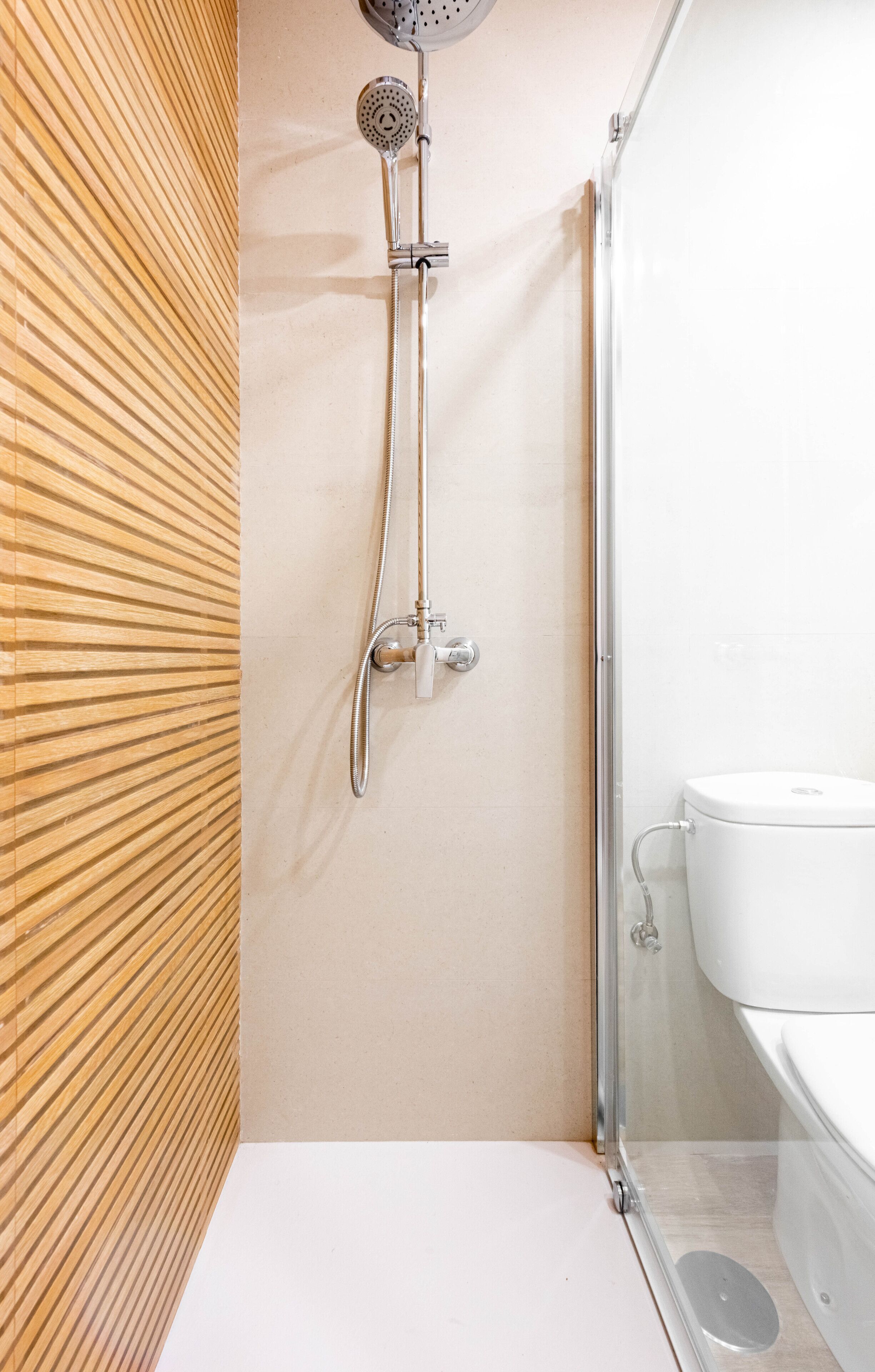 A modern bathroom with a shower, toilet, and sink.
