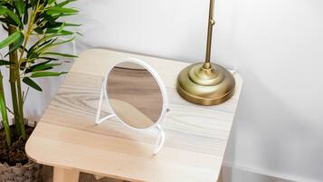 Une petite table en bois, avec une lampe et un miroir.