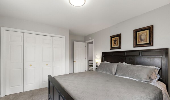 A bedroom with a bed, two framed pictures, a white door, and a white closet. - A/C, Hot Tub, Ping-Pong & Air Hockey, Pet Friendly (Durango)