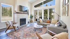 A spacious living room with a fireplace, large windows, and a comfortable seating area. - Hot Tub, Modern Home, Hiking and Fishing Close! (Durango)