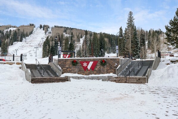 A snow-covered ski lift area with a stone wall, stairs, and a flag with a snowflake. - Hot Tub, Modern Home, Hiking and Fishing Close! (Durango)