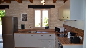 Una cocina con isla central, electrodomésticos de acero inoxidable y ventana con vistas.