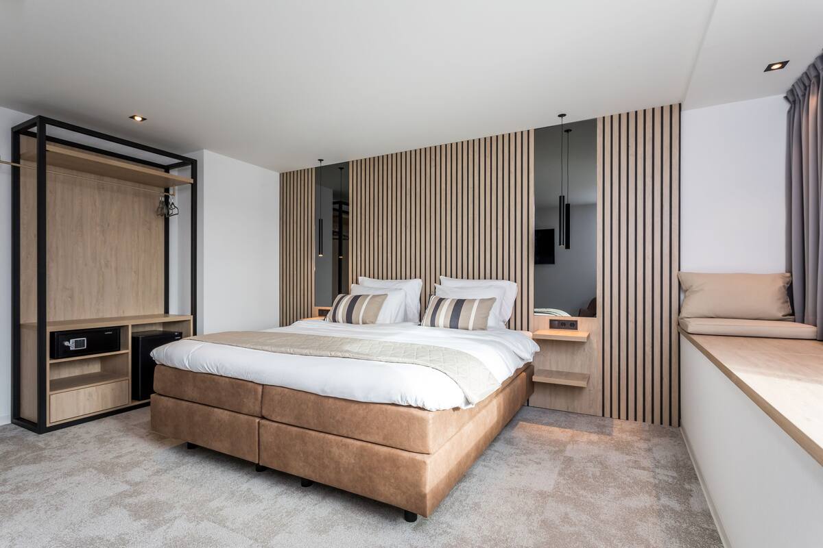 Un dormitorio moderno con una cama grande, armario empotrado y mesita de noche.