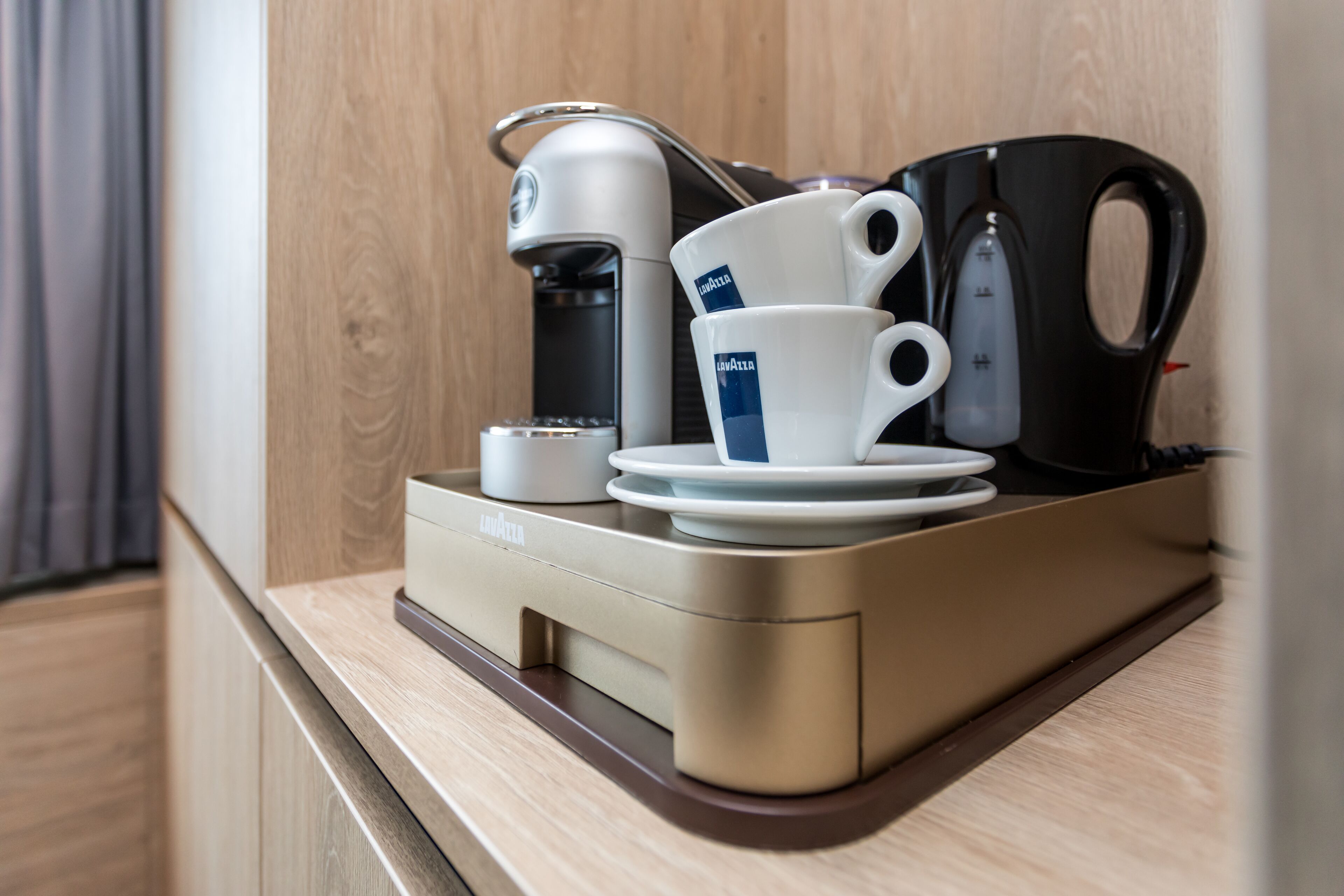 Une machine à café, une tasse et une bouilloire sur un plan de travail.