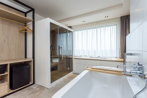 A modern bathroom with a freestanding bathtub, a glass shower enclosure, and a window with curtains.