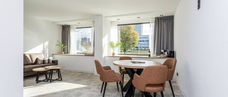 Una sala de estar moderna con un sofá, una mesa de centro y un comedor con sillas y una mesa.