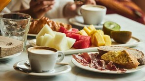 A breakfast setting with plates of food, coffee, and a glass of water. - Leonardo Boutique Hotel San Sebastián (San Sebastián)