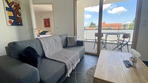 Una sala de estar moderna con un sofá gris, una manta estampada y una mesa de centro de madera.