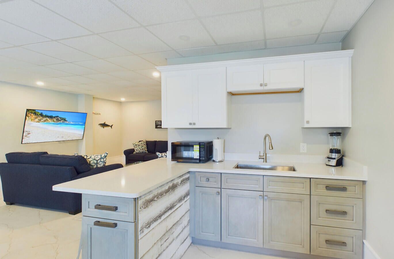 A modern kitchen with white cabinets, a built-in microwave, and a sink.