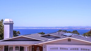 A residential area with houses, a chimney, and a view of the ocean. - 3827 Betsy's Nest - Adorable Monterey Cottage (Monterey)