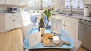 A kitchen with white cabinets, a granite countertop, a sink, and a window with a view. - 3827 Betsy's Nest - Adorable Monterey Cottage (Monterey)