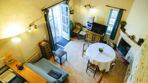 A compact living space with a kitchen, dining area, and a small seating area. - Charming gîte in the heart of the vineyards - Swimming pool, Jacuzzi & Air conditioning (Fressac)
