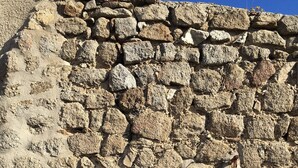 A stone wall with a doorway leading into a dark interior. - Charmante Maison Avec Toit Terrasse (Montalba-le-Château)