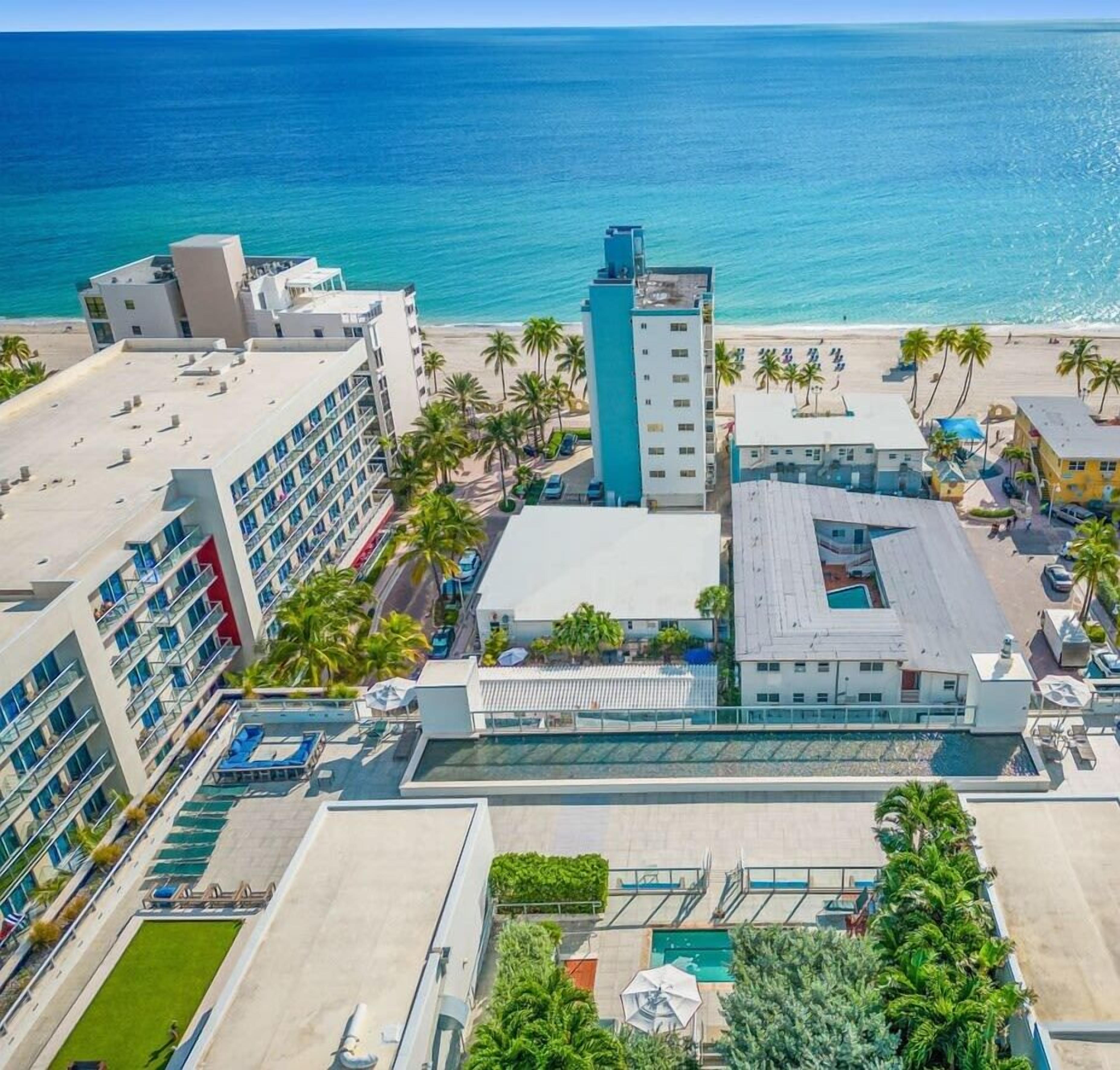 Hotel com vários edifícios, área de piscina e vista para a praia.