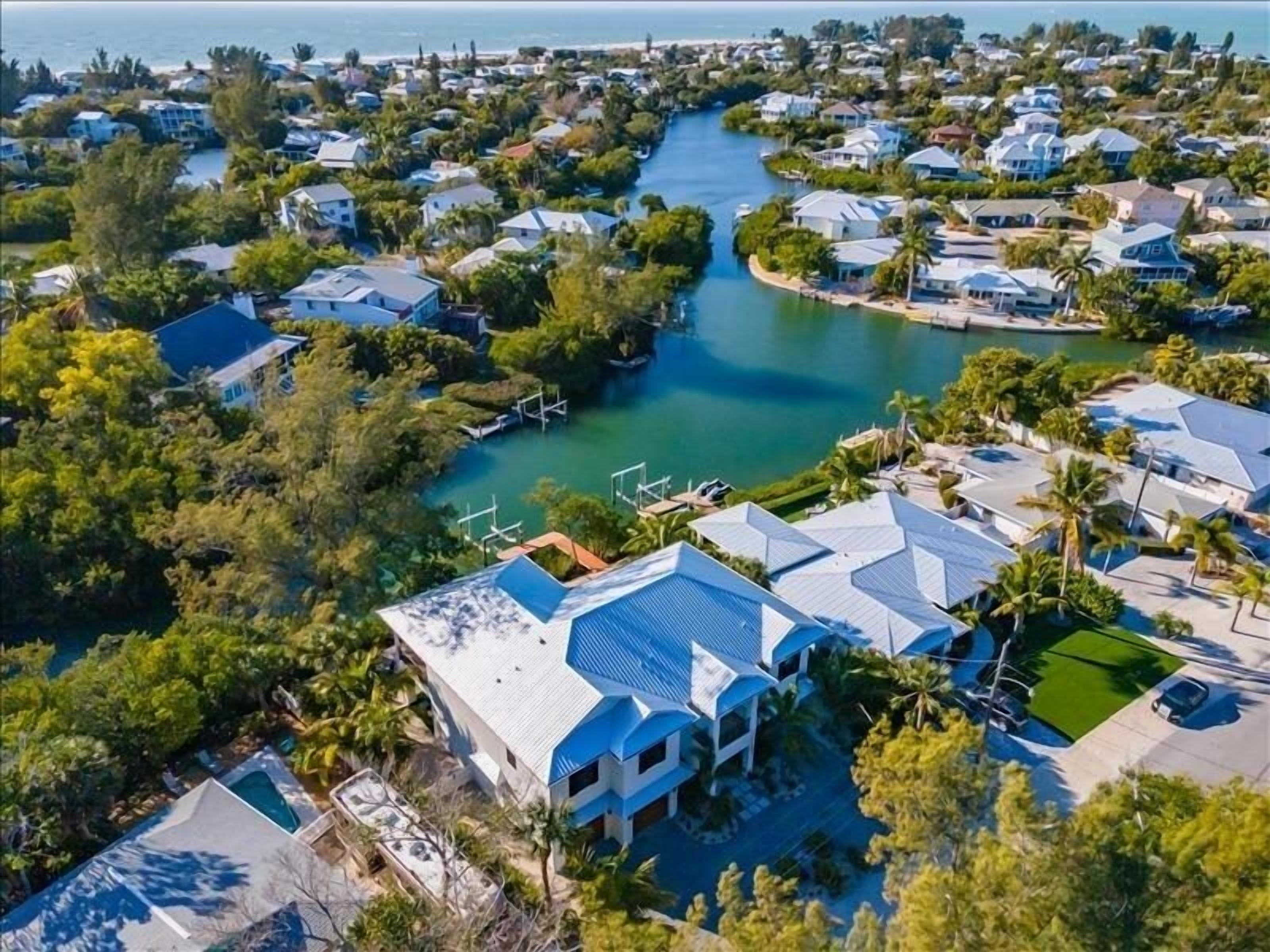 Vue aérienne d’un quartier résidentiel avec des maisons, une rivière et un quai.