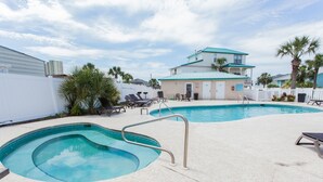 A swimming pool area with lounge chairs and a building in the background.