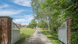A gated driveway leading to a brick building with a white gate. - Geoff's Rest with Hot Tub, Pond Hall Farm, Hadleig (Ipswich)