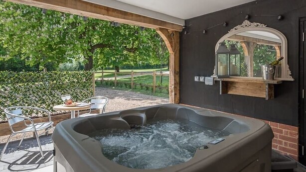 A hot tub area with a view of a garden and a wooden pergola. - Geoff's Rest with Hot Tub, Pond Hall Farm, Hadleig (Ipswich)