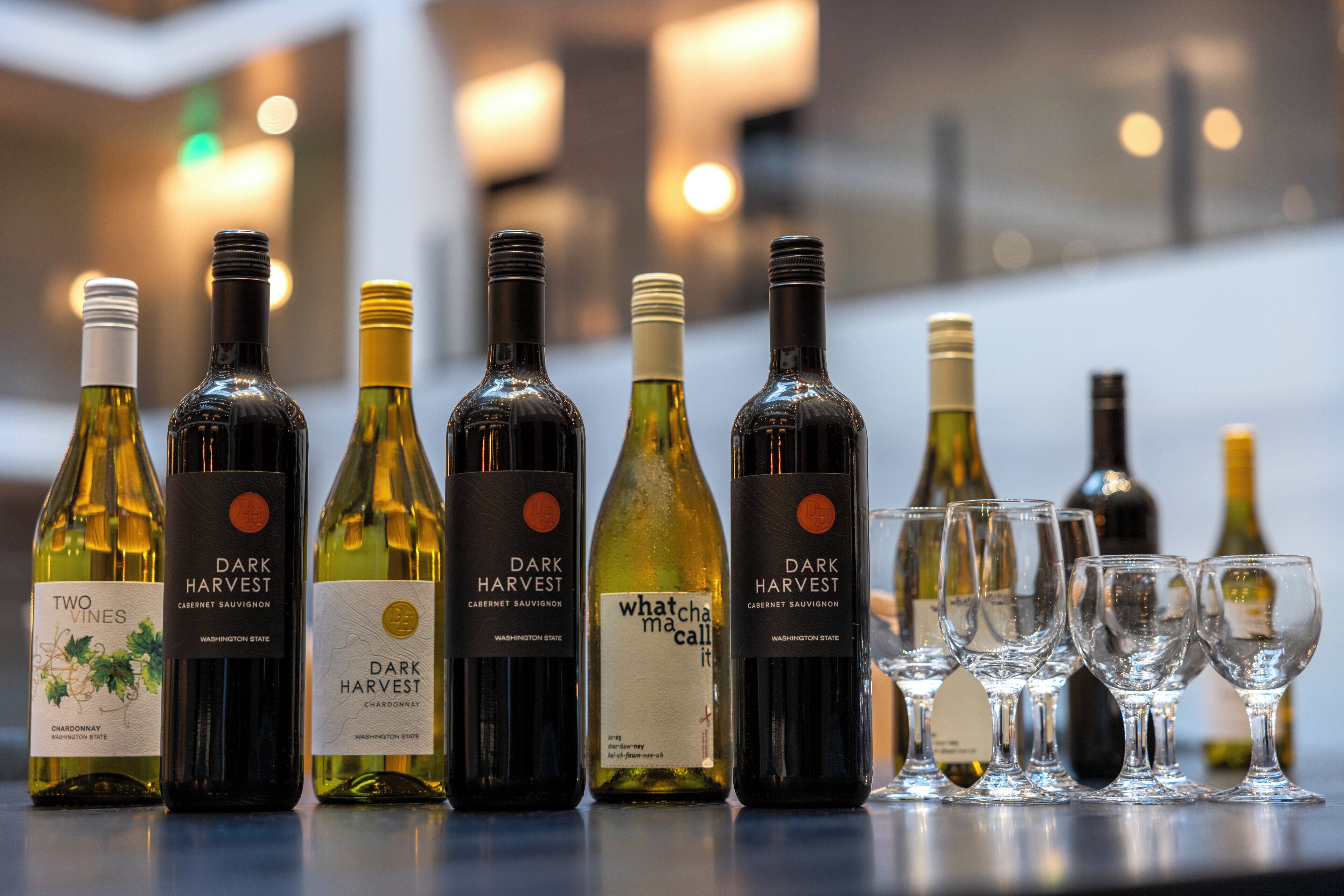 A selection of wine bottles and glasses on a bar counter.