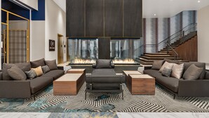 A modern living room with a fireplace, two sofas, and a coffee table. - Hotel Indigo Vancouver Dwtn – Portland Area by IHG (Vancouver)