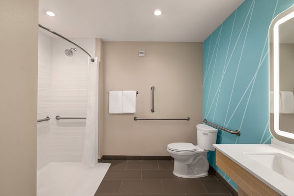 A modern bathroom with a shower, toilet, and sink. - avid hotel Memphis - Southaven by IHG (Southaven)