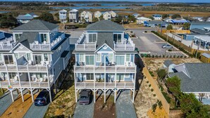 A coastal residential area with multiple two-story houses featuring balconies and a marina in the background.