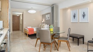 A modern hotel room with a dining area, a kitchenette, and a separate bedroom. - Spacious Studio Apartment on the Canals in CT (Cape Town)