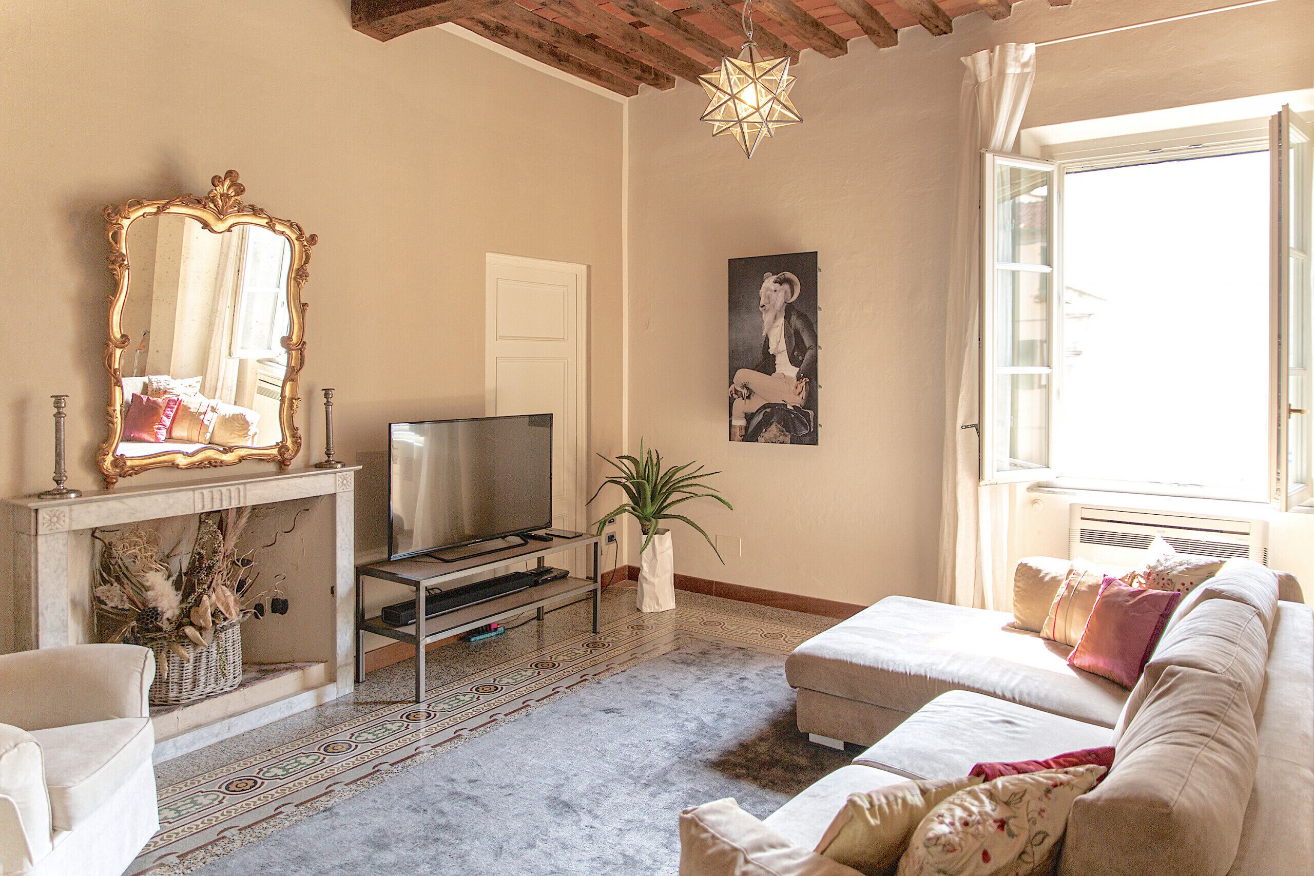 Ein Wohnzimmer mit Kamin, Fernseher, einer Couch und einem großen Spiegel.