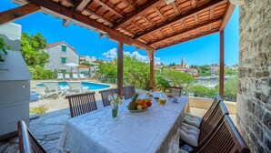 A covered outdoor dining area with a pool, stone walls, and a view of a town. - Villa Bonaca - Three Bedroom Villa, Sleeps 6 (Sumartin)