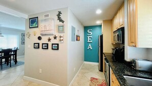 A modern kitchen with wooden cabinets, a microwave, and a refrigerator.