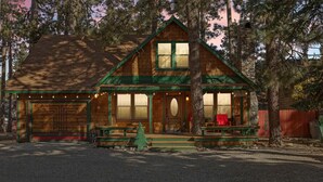 A rustic log cabin with a front porch, large windows, and a stone chimney. - A rustic retreat nestled in the heart of Boulder Bay (Big Bear Lake)