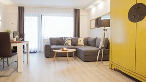 Una sala de estar moderna con sofá, mesa de centro y lámpara.