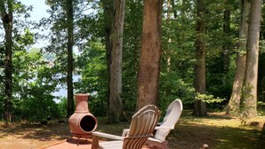 A wooden deck with two Adirondack chairs and a terracotta pot. - Grandma's Cottage Milford Delaware  (Milford)