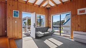 Um quarto aconchegante com paredes de madeira e um sofá cinzento.