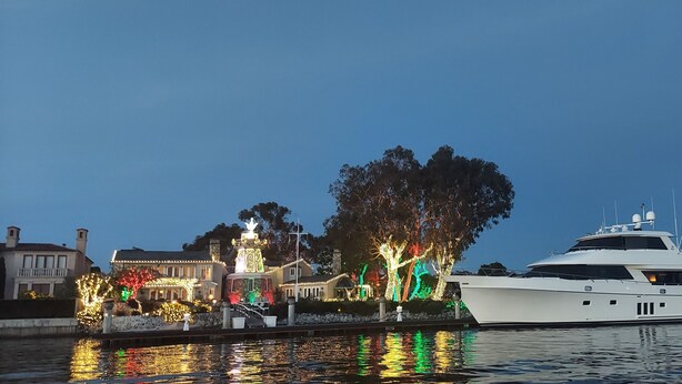 A large yacht docked at a marina with a well-lit building featuring a fountain and illuminated trees. - This Venue is set up for hourly rates only. 4.5 hour min.  Capacity 150 guests   (Costa Mesa)