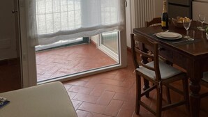Un comedor con una mesa lista para dos, una botella de champán y un refrigerador al fondo.