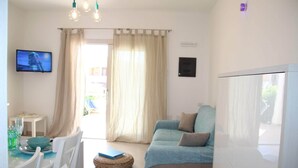 A modern living room with a sofa, dining table, and TV. - Mediterranean&sea Shell House (Limpiddu)