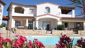 A two-story building with a swimming pool, stone walls, and outdoor furniture. - Mediterranean&sea Shell House (Limpiddu)