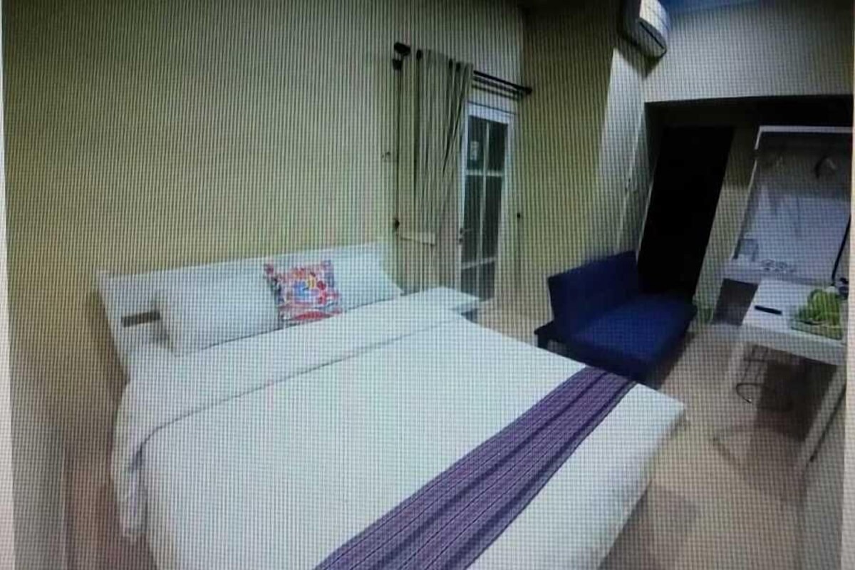 Ein Hotelzimmer mit Bett, Stuhl, Schreibtisch und Fenster.