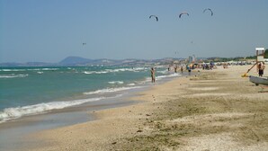 A beach with people, kites, and a lifeguard tower. - Ostra Villa - Sleeps 8 - Pool - Garden - Parking (Ostra)