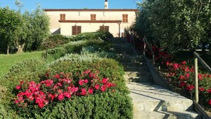A building with a staircase leading up to it, surrounded by well-maintained gardens and bushes. - Ostra Villa - Sleeps 8 - Pool - Garden - Parking (Ostra)