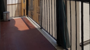 A balcony with a metal railing, a view of neighboring buildings, and a clear sky. - Appartamento Le Campane (Verona)