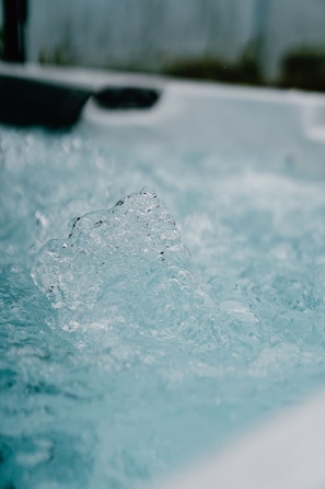 A close-up of a hot tub with clear water and bubbles.