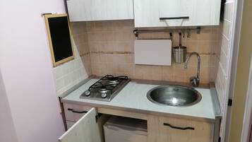 Kühlschrank, Herdplatte, Kochgeschirr/Geschirr/Besteck, Esstisch