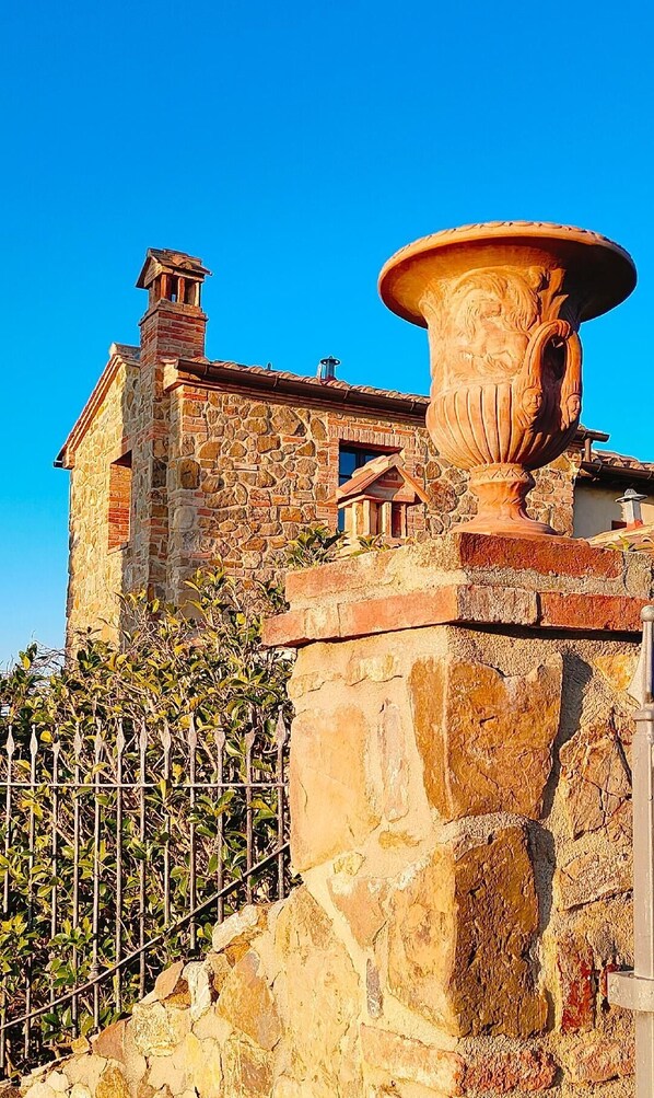 Traditional stone building with a charming facade, featuring a stone chimney and a small window.