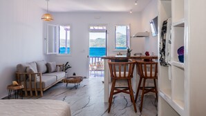 A modern living room with a sofa, coffee table, and a view of the sea. - The Colourful Land Klima, Milos (Klima)